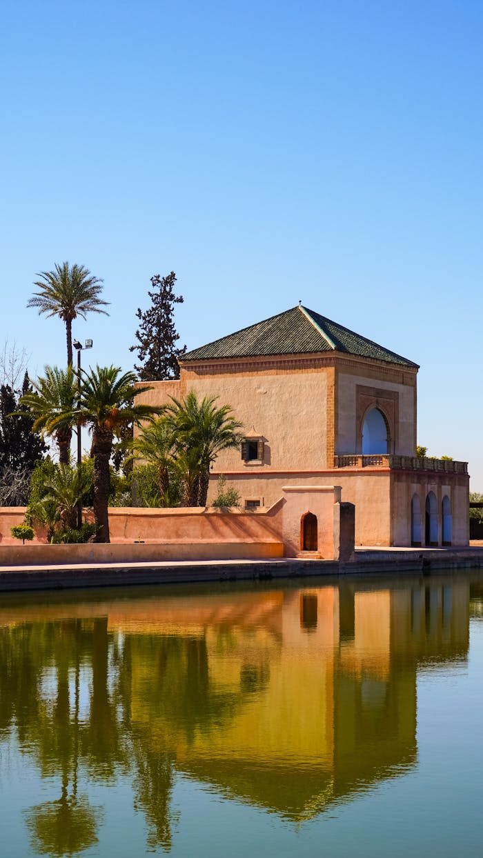 Beautiful reflection of the Menara Gardens pavilion in Marrakech on a sunny day with clear blue skies.